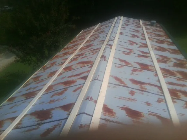 Rusted metal roof panels with new wood purlins before replacement — Storm Damage Roof Repair in Laurier by Roofing Brothers
