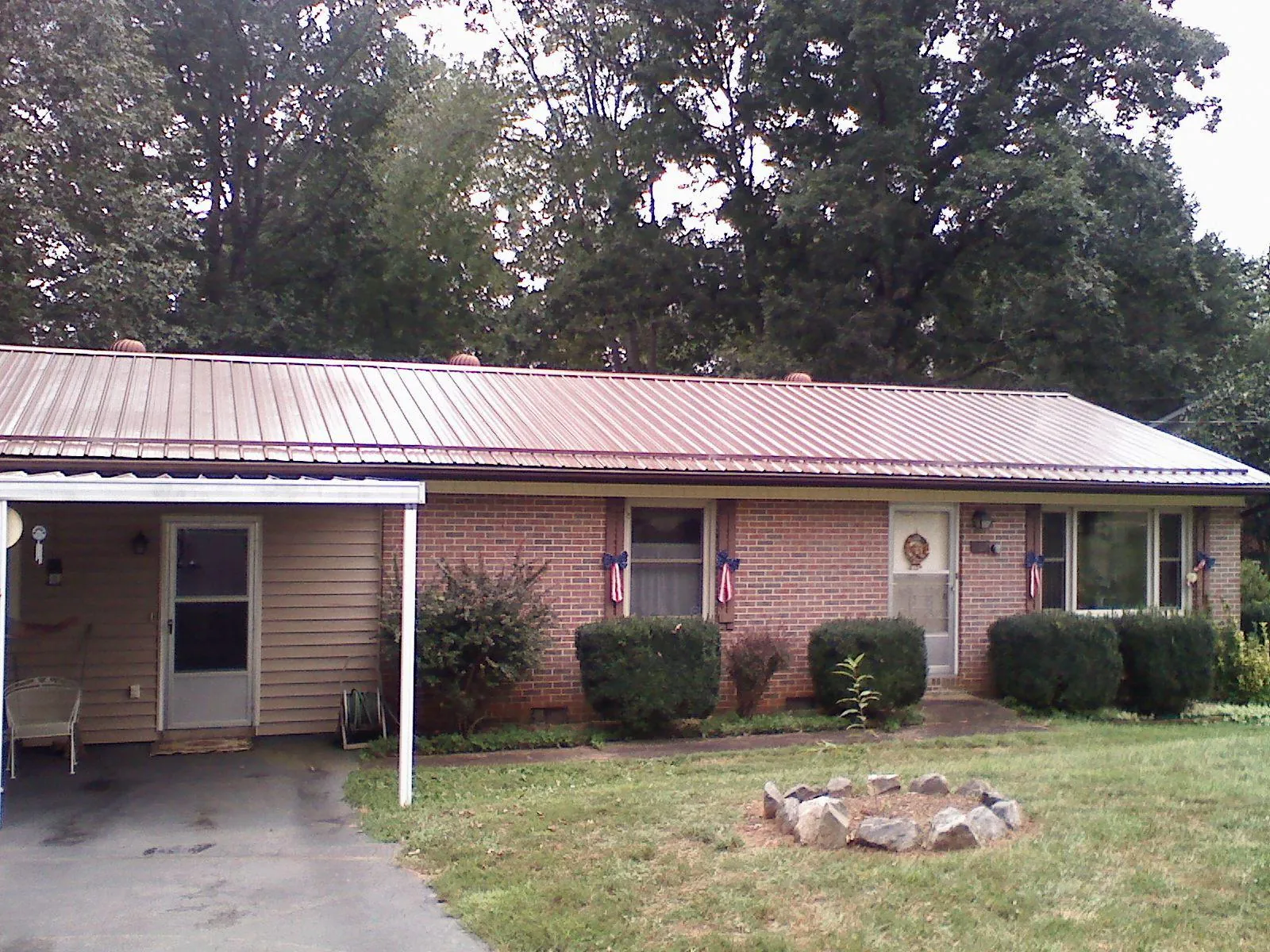 Bronze metal roof and carport on a brick ranch home — Roof Repair work by our crew in Laurier